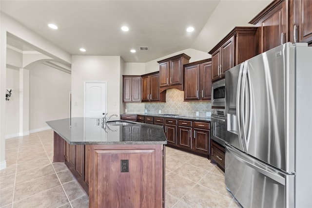 kitchen with light tile patterned floors, visible vents, a sink, stainless steel appliances, and tasteful backsplash