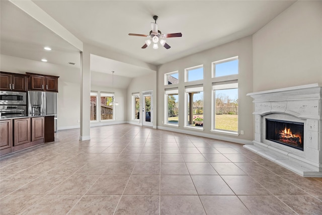 unfurnished living room with a high end fireplace, baseboards, and light tile patterned flooring