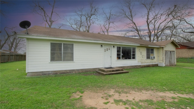 rear view of property with a yard and fence