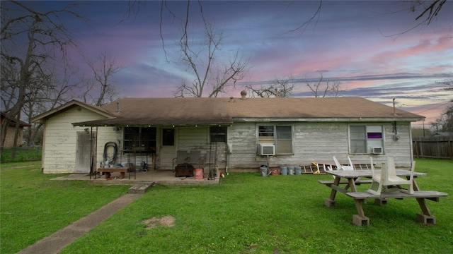 602 Riveredge Dr, Richmond, TX 77406 - back of property at dusk with a patio area, cooling unit, a lawn, and fence