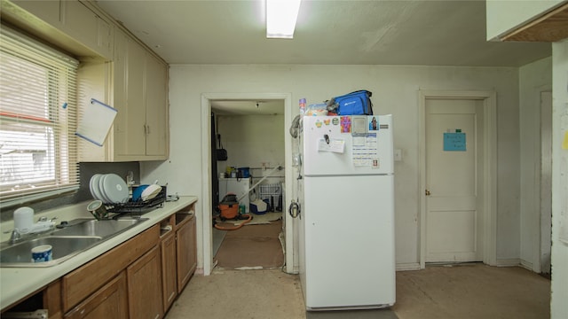 602 Riveredge Dr, Richmond, TX 77406 - kitchen featuring a sink, brown cabinets, light countertops, and freestanding refrigerator