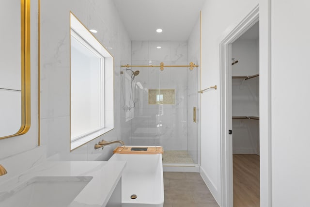 full bath with vanity, a spacious closet, recessed lighting, and a marble finish shower