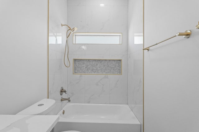 bathroom featuring washtub / shower combination, toilet, and vanity