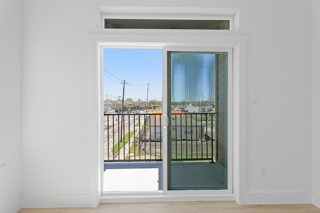 doorway with wood finished floors and baseboards