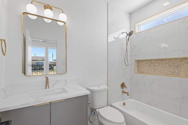 bathroom with vanity, toilet, a healthy amount of sunlight, and shower / bath combination