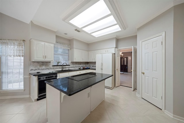 kitchen with tasteful backsplash, black appliances, a kitchen island, white cabinetry, and a sink