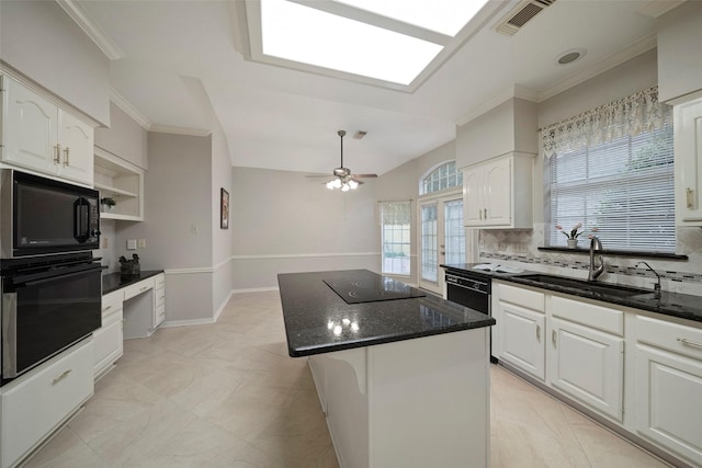 kitchen featuring visible vents, dark stone counters, white cabinets, black appliances, and a sink