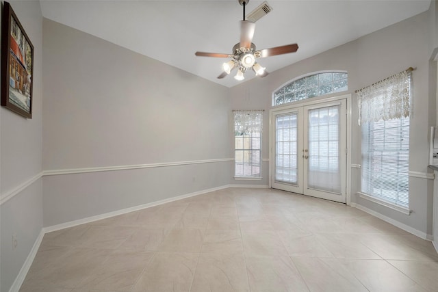 unfurnished room with light tile patterned floors, visible vents, baseboards, vaulted ceiling, and french doors