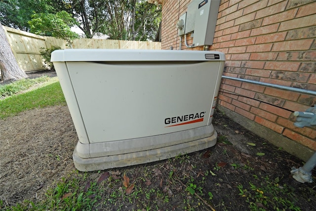 details featuring a power unit, brick siding, electric meter, and fence