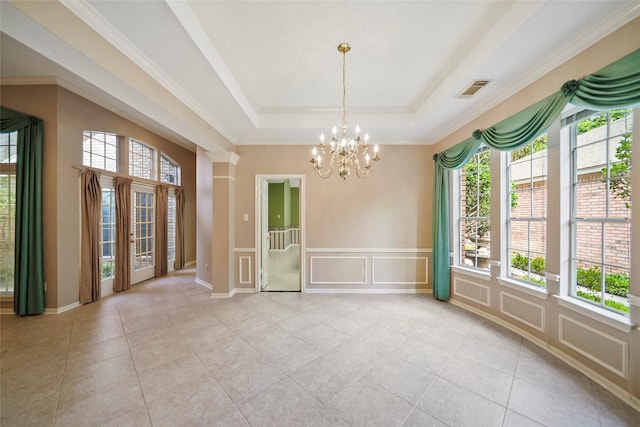 unfurnished room featuring a notable chandelier, a decorative wall, a raised ceiling, and light tile patterned floors