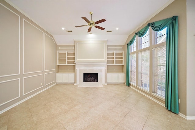 unfurnished living room featuring a high end fireplace, a decorative wall, built in shelves, and visible vents