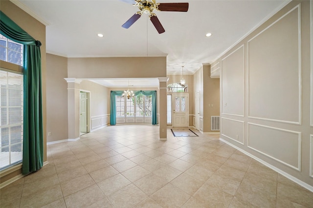 empty room featuring a decorative wall, crown molding, visible vents, and decorative columns