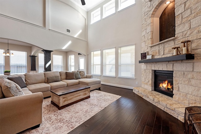 living area with a fireplace, wood finished floors, visible vents, and a healthy amount of sunlight