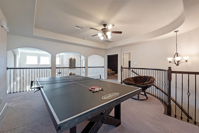 rec room with visible vents, a raised ceiling, carpet floors, and an inviting chandelier