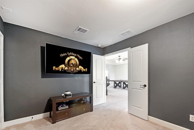 hall featuring baseboards, visible vents, carpet floors, and a textured ceiling