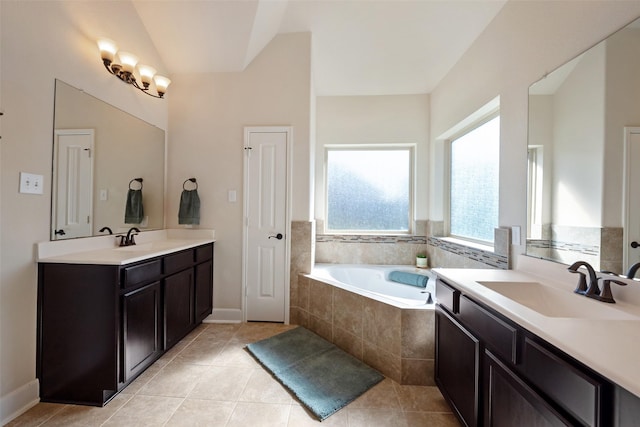 bathroom featuring lofted ceiling, a bath, tile patterned floors, and a sink