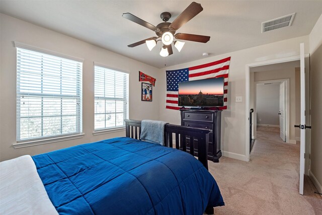 bedroom with light carpet, visible vents, a ceiling fan, and baseboards