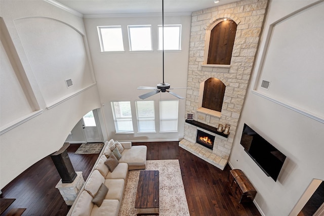 living room with dark wood finished floors, visible vents, a healthy amount of sunlight, and a fireplace