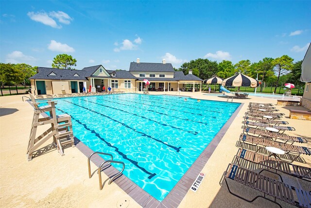 community pool featuring a patio area and fence