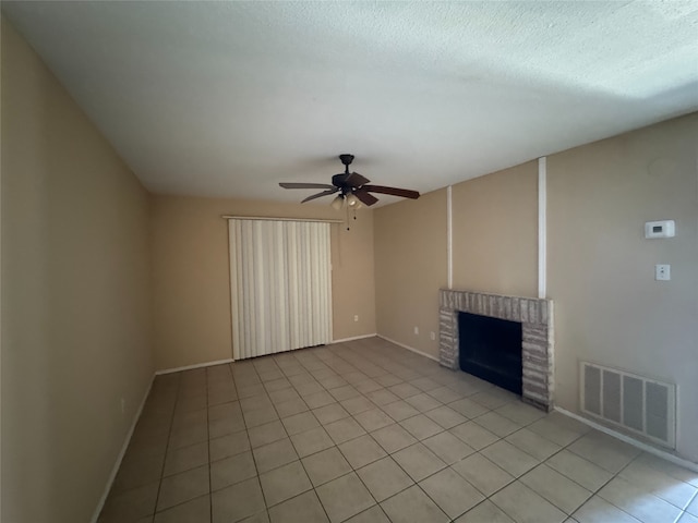 unfurnished living room featuring a brick fireplace, light tile patterned floors, a ceiling fan, and visible vents