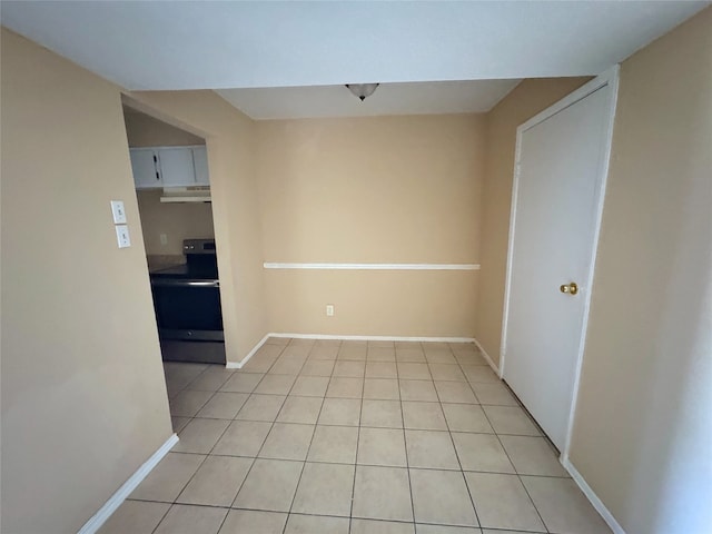 unfurnished room featuring light tile patterned floors and baseboards