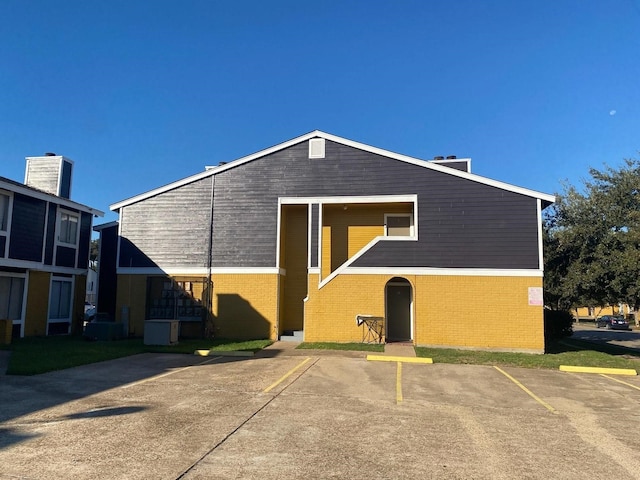 exterior space featuring uncovered parking and brick siding