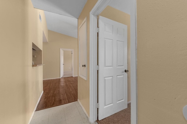 hall with baseboards and visible vents