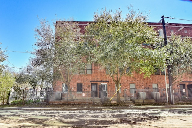 view of front facade with a fenced front yard and brick siding