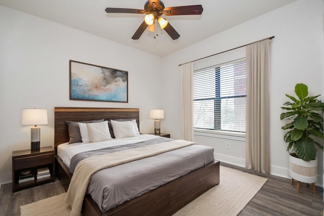 bedroom with a ceiling fan, wood finished floors, and baseboards