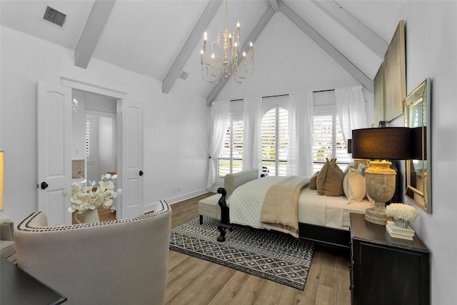 bedroom featuring visible vents, baseboards, beamed ceiling, and wood finished floors