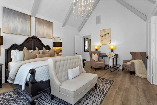 bedroom with beam ceiling, wood finished floors, visible vents, and a chandelier