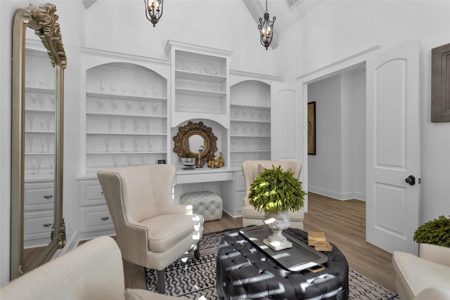 interior space with baseboards, high vaulted ceiling, and wood finished floors