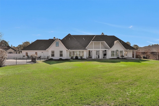 back of house featuring a lawn and fence