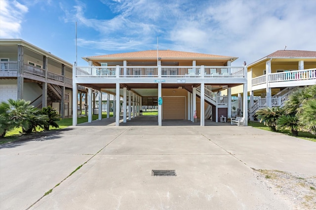 beach home featuring a carport, driveway, stairs, and a garage