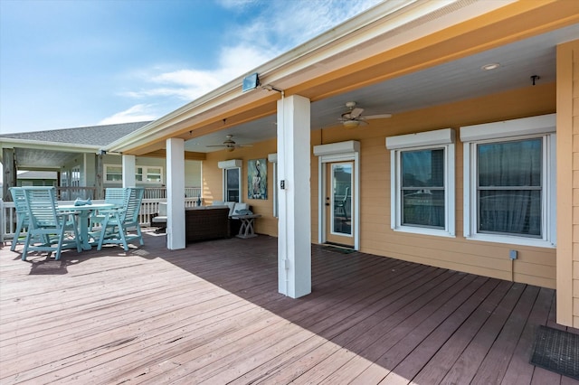 wooden deck with outdoor dining space, an outdoor hangout area, and ceiling fan