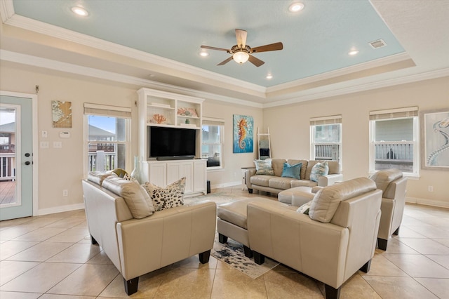 living area featuring a ceiling fan, visible vents, light tile patterned flooring, crown molding, and a raised ceiling