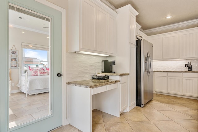 kitchen with tasteful backsplash, ornamental molding, stainless steel refrigerator with ice dispenser, light tile patterned flooring, and white cabinets