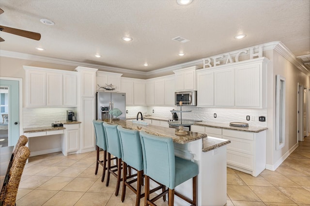 kitchen with light tile patterned flooring, visible vents, white cabinets, and stainless steel appliances