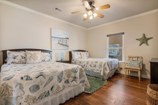 bedroom featuring visible vents, baseboards, wood finished floors, and ornamental molding