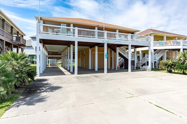 beach home featuring stairs, a carport, and concrete driveway