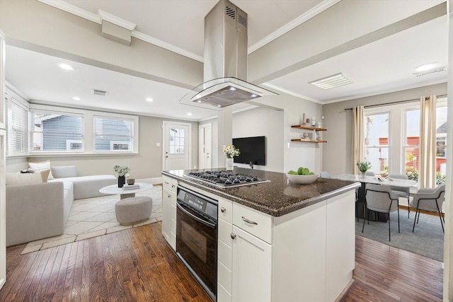 kitchen with island exhaust hood, black oven, open floor plan, crown molding, and stainless steel gas cooktop