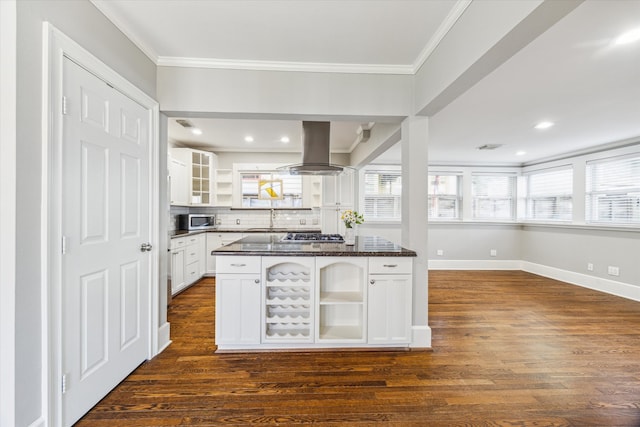 kitchen with open shelves, ornamental molding, stainless steel appliances, dark countertops, and island range hood