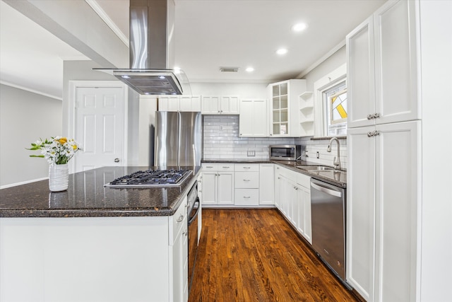 kitchen with visible vents, island exhaust hood, a sink, appliances with stainless steel finishes, and crown molding