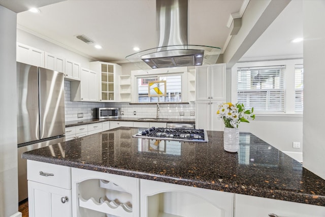 kitchen featuring open shelves, ornamental molding, appliances with stainless steel finishes, island range hood, and a sink