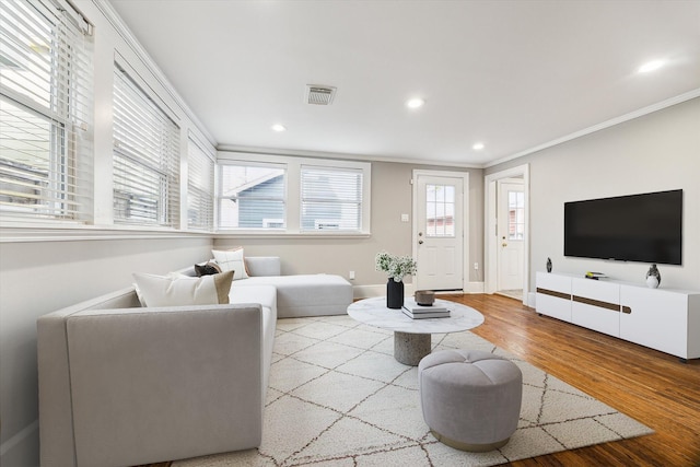 living room featuring crown molding, recessed lighting, wood finished floors, and visible vents