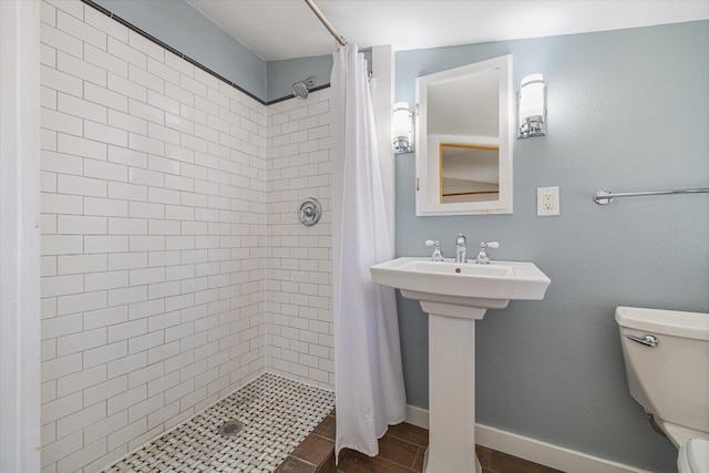 full bath with baseboards, toilet, and a shower stall