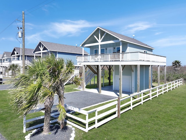 view of front facade with fence, stairway, board and batten siding, a front yard, and a carport