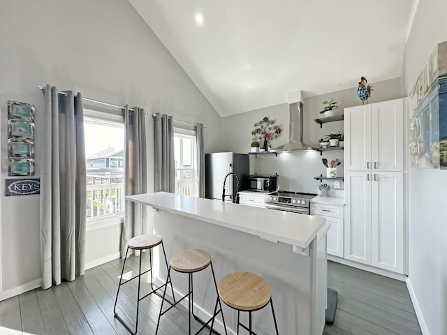 kitchen with open shelves, white cabinetry, stainless steel appliances, wall chimney range hood, and vaulted ceiling