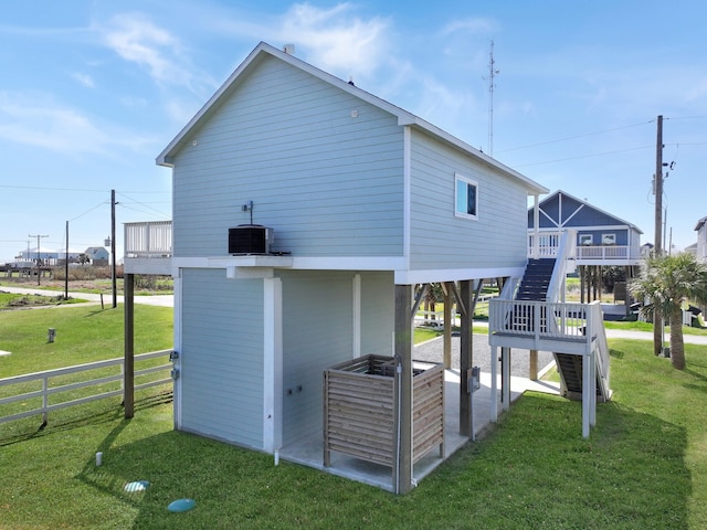 1040 Johnson Rd, Gilchrist, TX 77617 - view of side of home featuring fence, central AC, stairway, and a yard