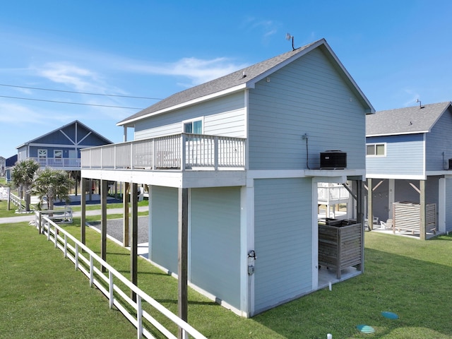 rear view of property with central AC, a lawn, and roof with shingles